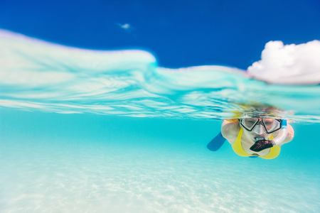 Split photo of young woman snorkeling in tropical oceanの写真素材