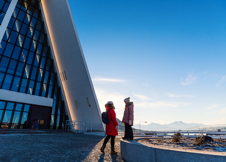 Beautiful family of mother and daughter enjoying sunny winter day outdoors in Tromso in Northern Norwayの写真素材