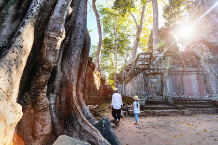 Family visiting ancient Ta Prohm temple in Angkor Archaeological area in Cambodiaの写真素材