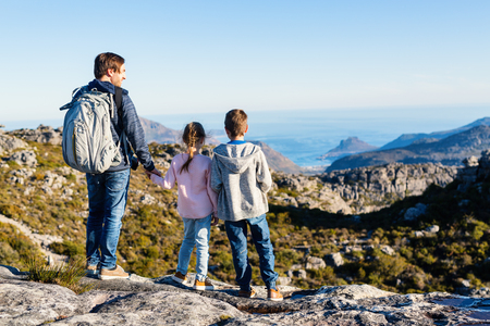 Family father and his two kids enjoying breathtaking views of Cape Town from top of Table mountainの写真素材