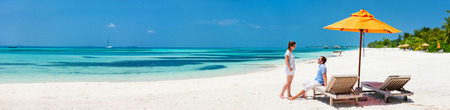 Romantic couple on a tropical beach during honeymoon vacation, wide panorama perfect for bannersの写真素材