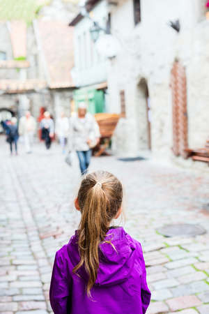 Back view of adorable girl outdoors exploring Tallinn old townの写真素材