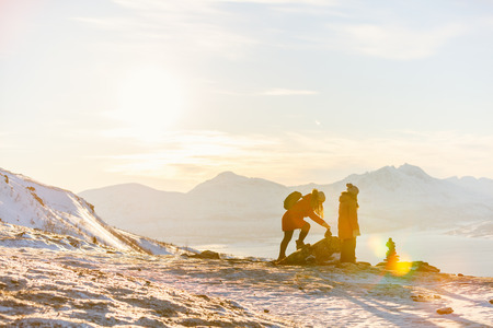 Beautiful family of mother and daughter enjoying snowy winter day outdoors in Northern Norwayの写真素材