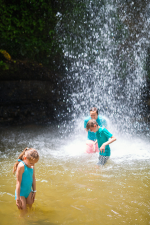 Family of father and kids having fun swimming in waterfall on Saint Lucia island in Caribbeanの写真素材