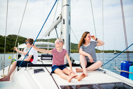 Mother and kids on board of sailing yacht having summer travel adventureの写真素材
