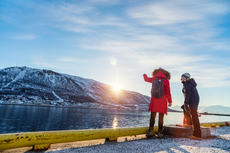 Beautiful family of mother and son enjoying winter day outdoors in Tromso town surrounded by fjords in Northern Norwayの写真素材