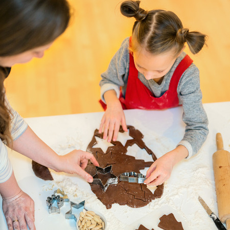 Family of mother and daughter baking chocolate cookies at homeの写真素材