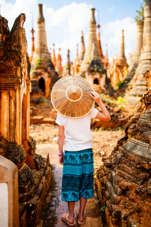 Young girl visiting hundrets of centuries old stupas in Indein near lake Inle in Myanmarの写真素材