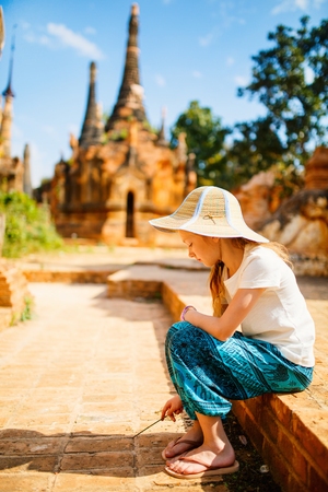 Young girl visiting hundrets of centuries old stupas in Indein near lake Inle in Myanmarの写真素材