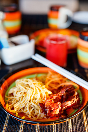 Delicious fresh noodles with crispy bacon served for breakfastの写真素材