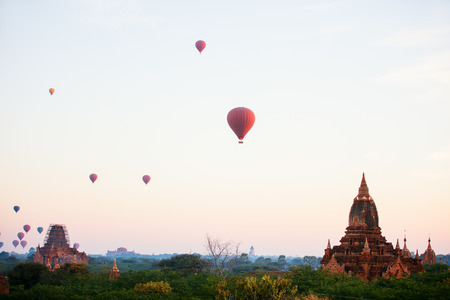 Stunning landscape view of hot air balloons fly over thousands of ancient pagodas at morning in Bagan Myanmarの写真素材