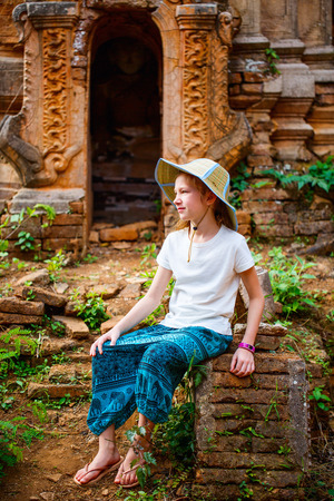 Young girl visiting hundrets of centuries old stupas in Indein near lake Inle in Myanmarの写真素材