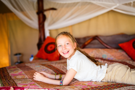 Little girl in safari tent enjoying  luxury vacation in Africaの写真素材