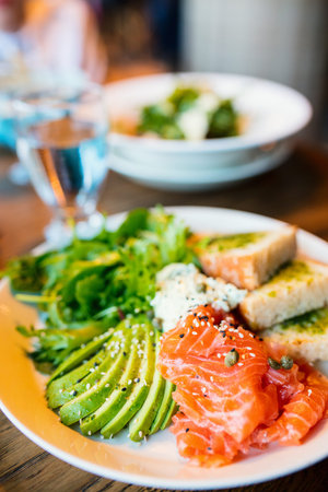 Delicious fresh avocado slices and freshly salted salmon served for lunch