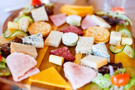 Appetizers platter with cheese and cold meat served in a restaurantの写真素材