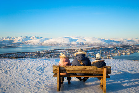 Back view of beautiful family of dad and kids have a pleasant time on snowy winter day outdoors...