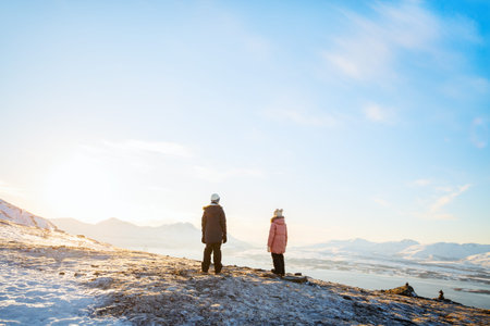 Adorable little girl and cute boy enjoying snowy winter day outdoors in Northern Norway