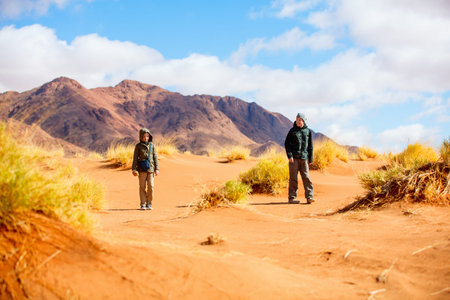 Two kids brother and sister enjoying stunning view over Tiras mountains in Namib desert during...