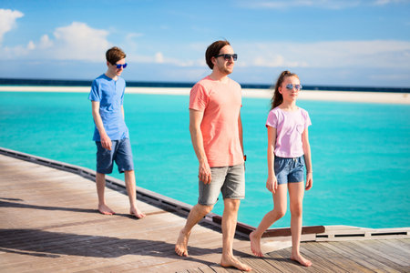 Father and kids enjoying summer beach vacation on tropical island resort