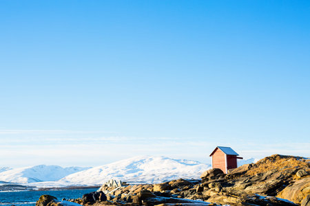 Beautiful winter landscape of Northern Norway coast with wooden huts overlooking breathtaking fjords...