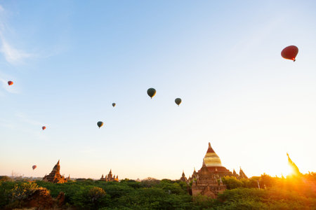 Stunning landscape view of hot air balloons fly over thousands of ancient pagodas at morning in...