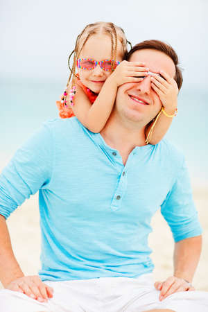 Happy father and his sweet little daughter at beachの写真素材