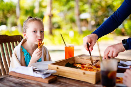 Adorable little girl eating pizza for lunchの写真素材