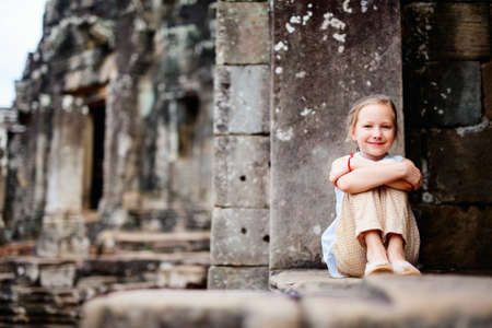 Little girl in beautiful ancient Bayon temple in Siem Reap Cambodiaの写真素材