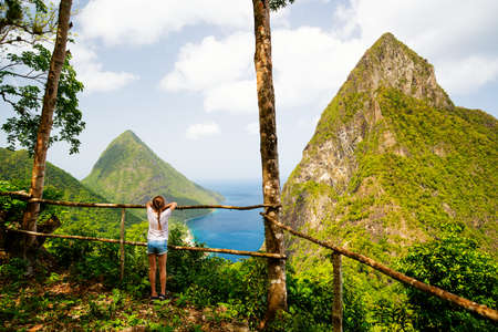 Back view of little girl enjoying scenery of Piton mountains on St Lucia island in Caribbeanの写真素材