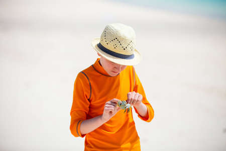 Teen age boy holding crab at beachの写真素材