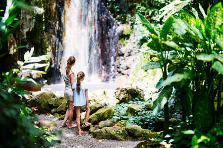 Back view family of mother and daughter enjoying view of Diamond waterfall on Saint Lucia island in Caribbeanの写真素材