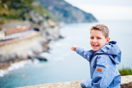 Little boy enjoying scenic view of colorful Vernazza village, Cinque Terre, Italy