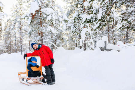 Adorable little girl and cute boy outdoors on beautiful winter day having fun playing in snowの写真素材