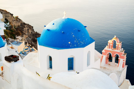 Blue domed church in Oia overlooking spectacular caldera surrounding beautiful island of Santorini in Greeceの写真素材