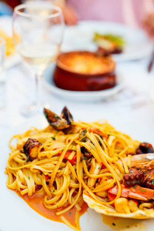 Delicious seafood spaghetti served with white wine for lunch or dinner in restaurant