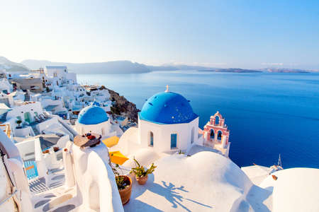 Blue domed church in Oia overlooking spectacular caldera surrounding beautiful island of Santorini in Greeceの写真素材
