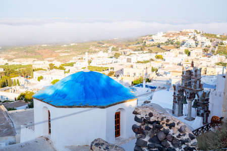 Breathtaking view of Pyrgos village with traditional white architecture and blue-domed churches on Santorini island in Greeceの写真素材