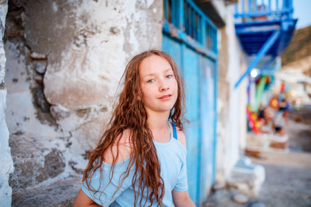 Adorable teenage girl enjoying visit to colorful fishing village of Klima on the island of Milos in Greeceの写真素材