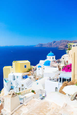 Blue domed church in Oia overlooking spectacular caldera surrounding beautiful island of Santorini in Greeceの写真素材