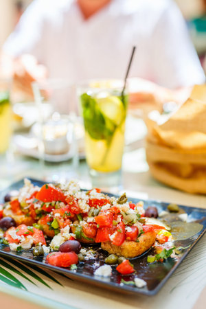 Fresh homemade crispy Greek antipasto bruschetta topped with tomato, olives and feta cheese