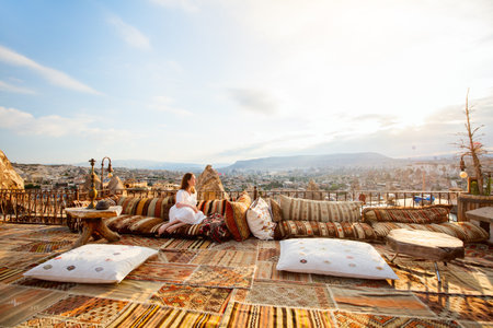 Young woman relaxing on terrace with amazing morning view over Goreme town in Cappadocia Turkeyの写真素材