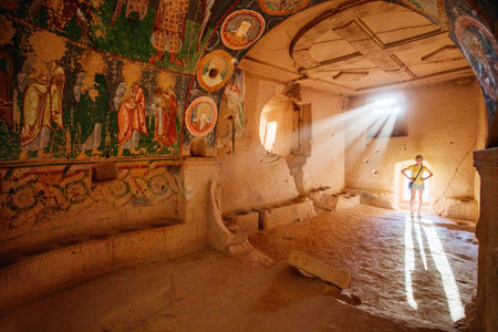 Teenage girl exploring cave church in Rose Valley in Cappadocia Turkey dated back to 10th centuryの写真素材