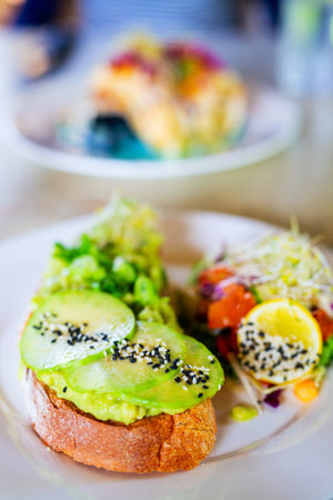 Healthy breakfast with avocado toast and fresh green saladの写真素材