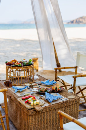 Luxury picnic on beautiful white sand beach at sunsetの写真素材