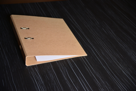 Brown folder on a black office tableの写真素材