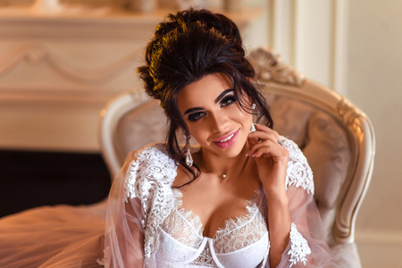 Boudoir morning of the bride. The bride sits on a chairの写真素材