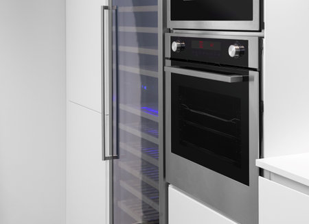 Built in oven and wine cabinet in a white kitchenの写真素材