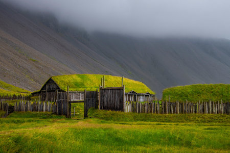 Old wooden house with grass roof and fenceの写真素材