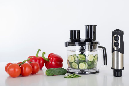 Electric immersion blender with vegetables on a tableの写真素材