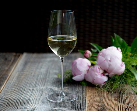 Champagne glass on a wooden table with flowersの写真素材